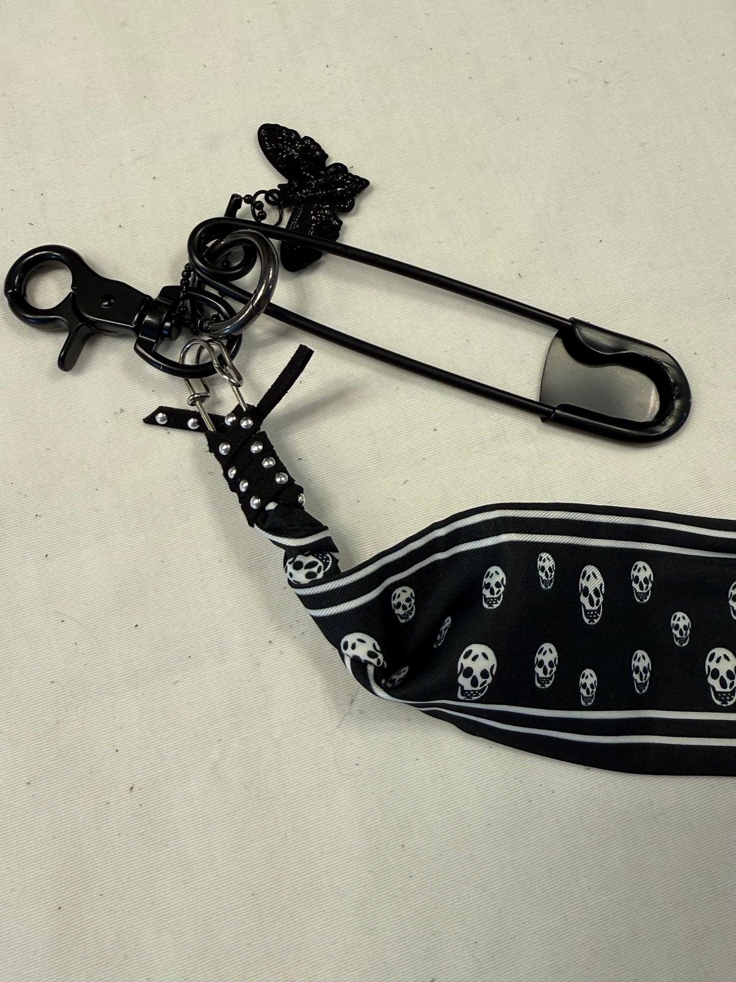 Bag Charm Cluster on Black Hardware with a Skull Scarf, XL Black Safety Pin, and Skull Moth Charm