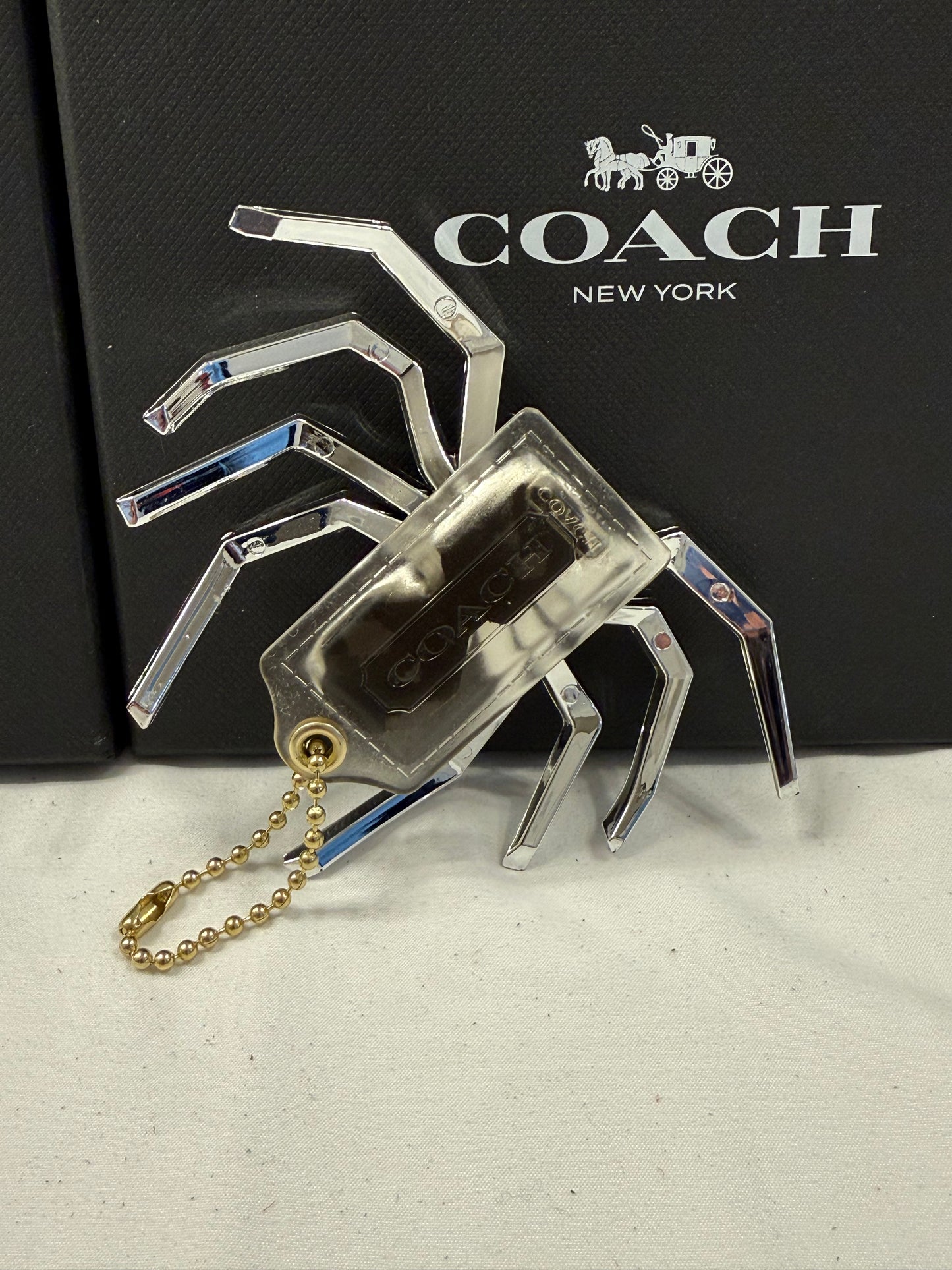 Repurposed Coach Clear (Yellowed) Hangtag with Metallic Plastic Spider Emblem