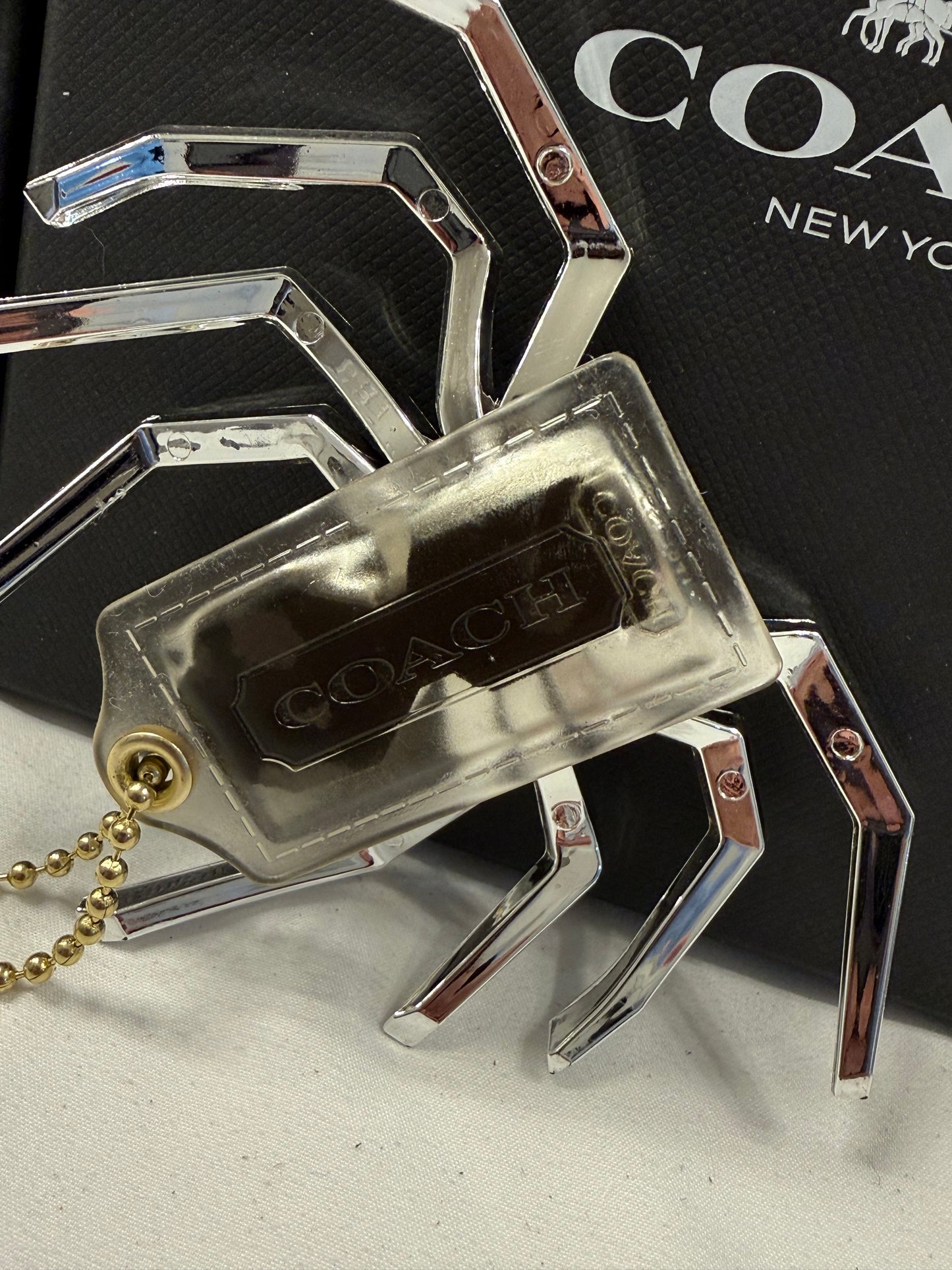 Repurposed Coach Clear (Yellowed) Hangtag with Metallic Plastic Spider Emblem