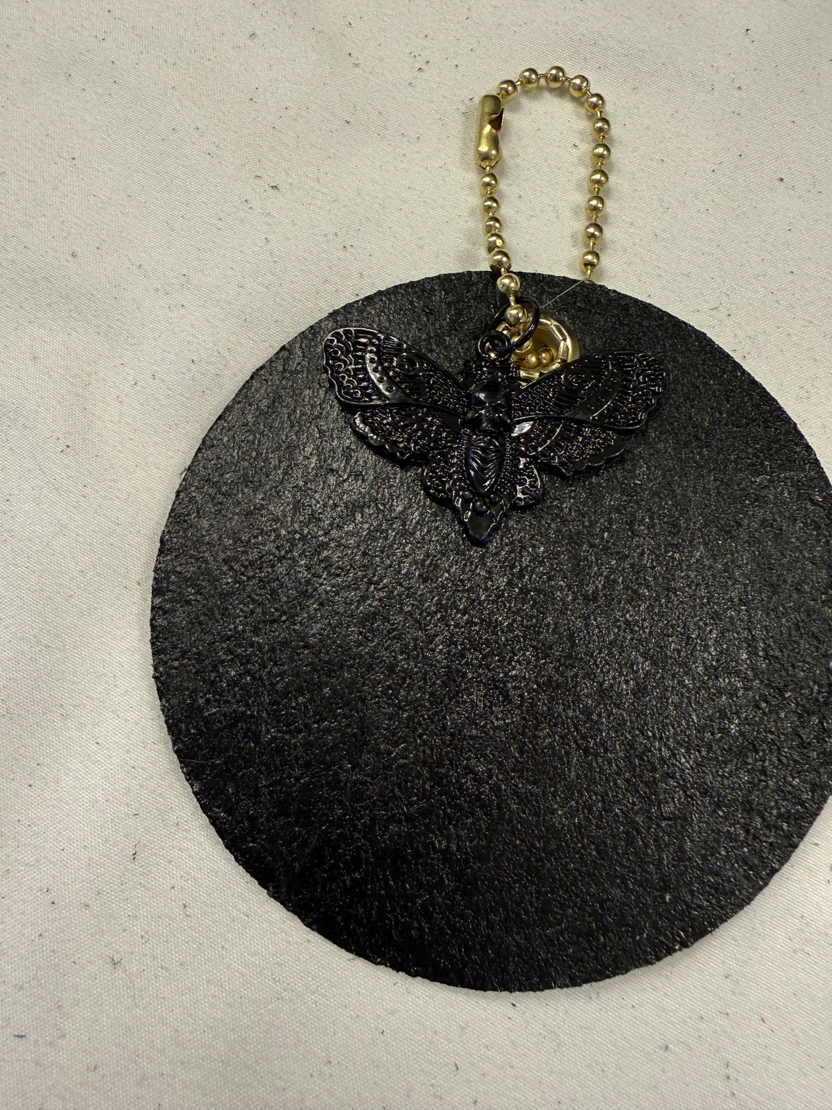 Stenciled and Painted Leather Disc with Butterfly and Skull Moth Charm