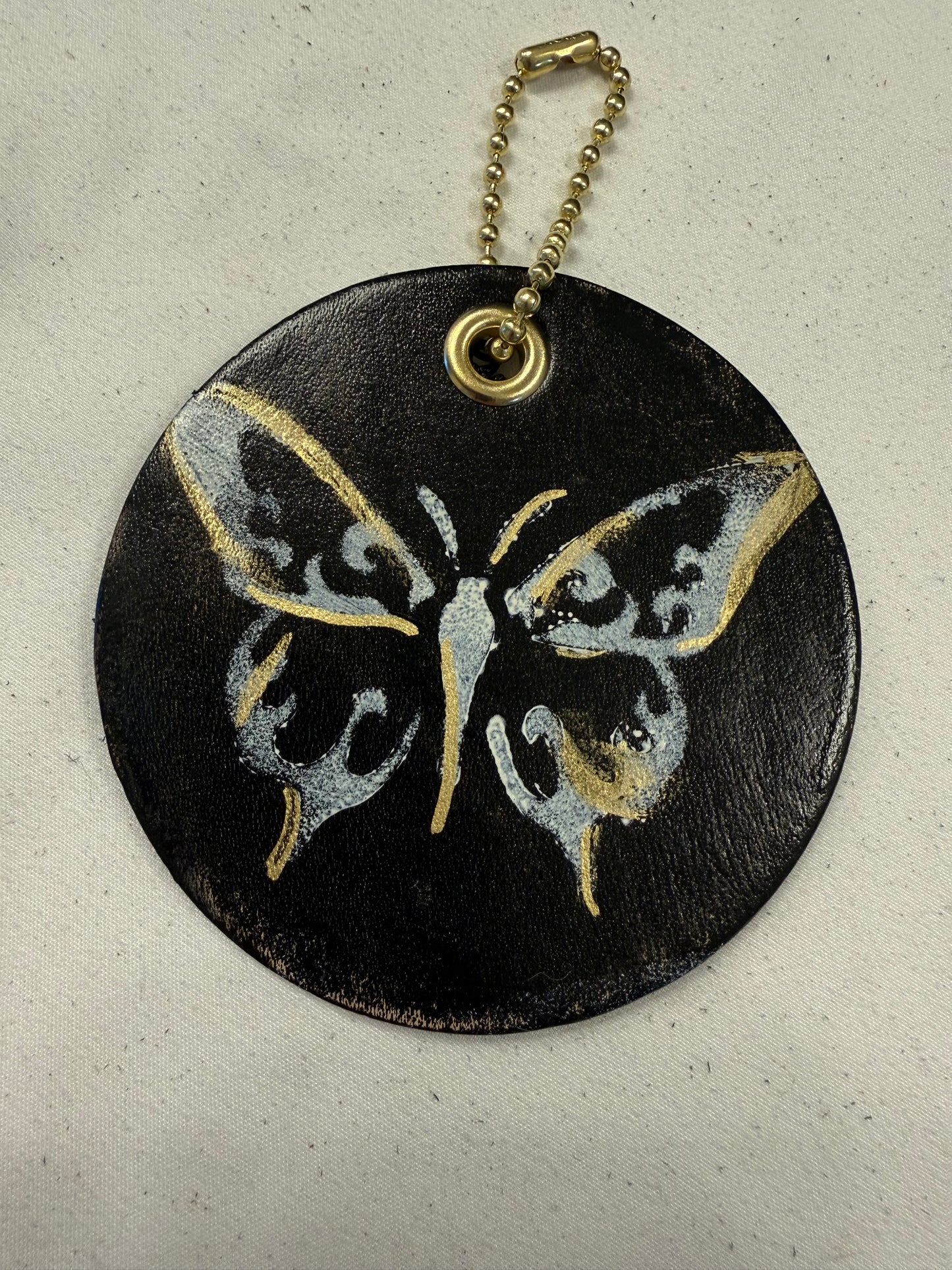 Stenciled and Painted Leather Disc with Butterfly and Skull Moth Charm