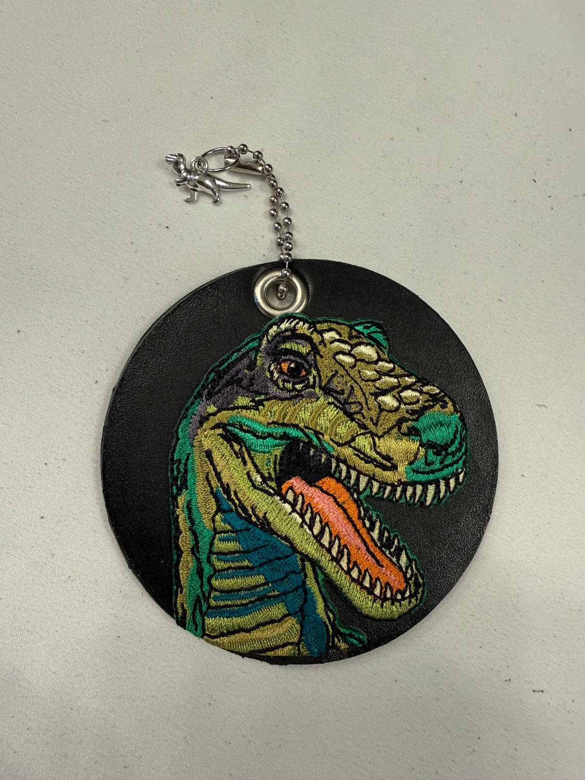 Repurposed Center of a Coach Coaster with T-Rex Embroidered Patch Bag Charm Silver Hardware