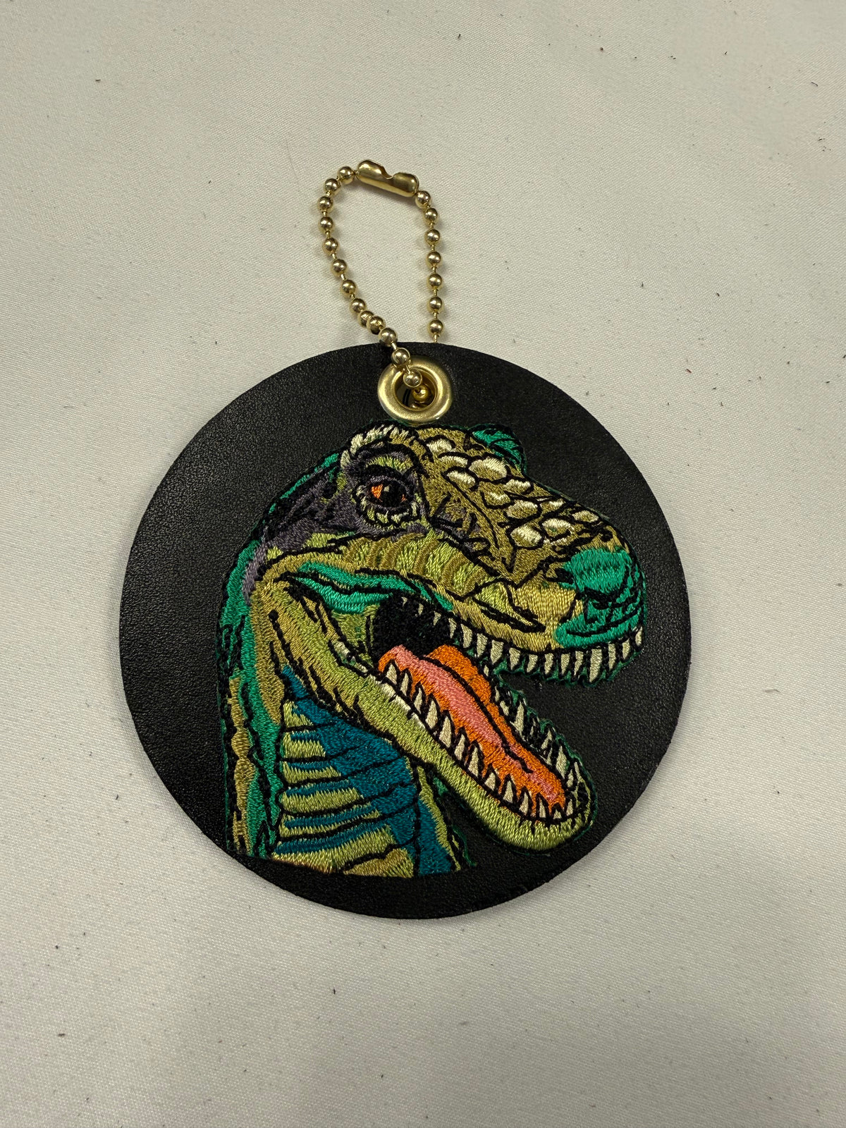 Repurposed Center of a Coach Coaster with Embroidered T-Rex Patch Bag Charm