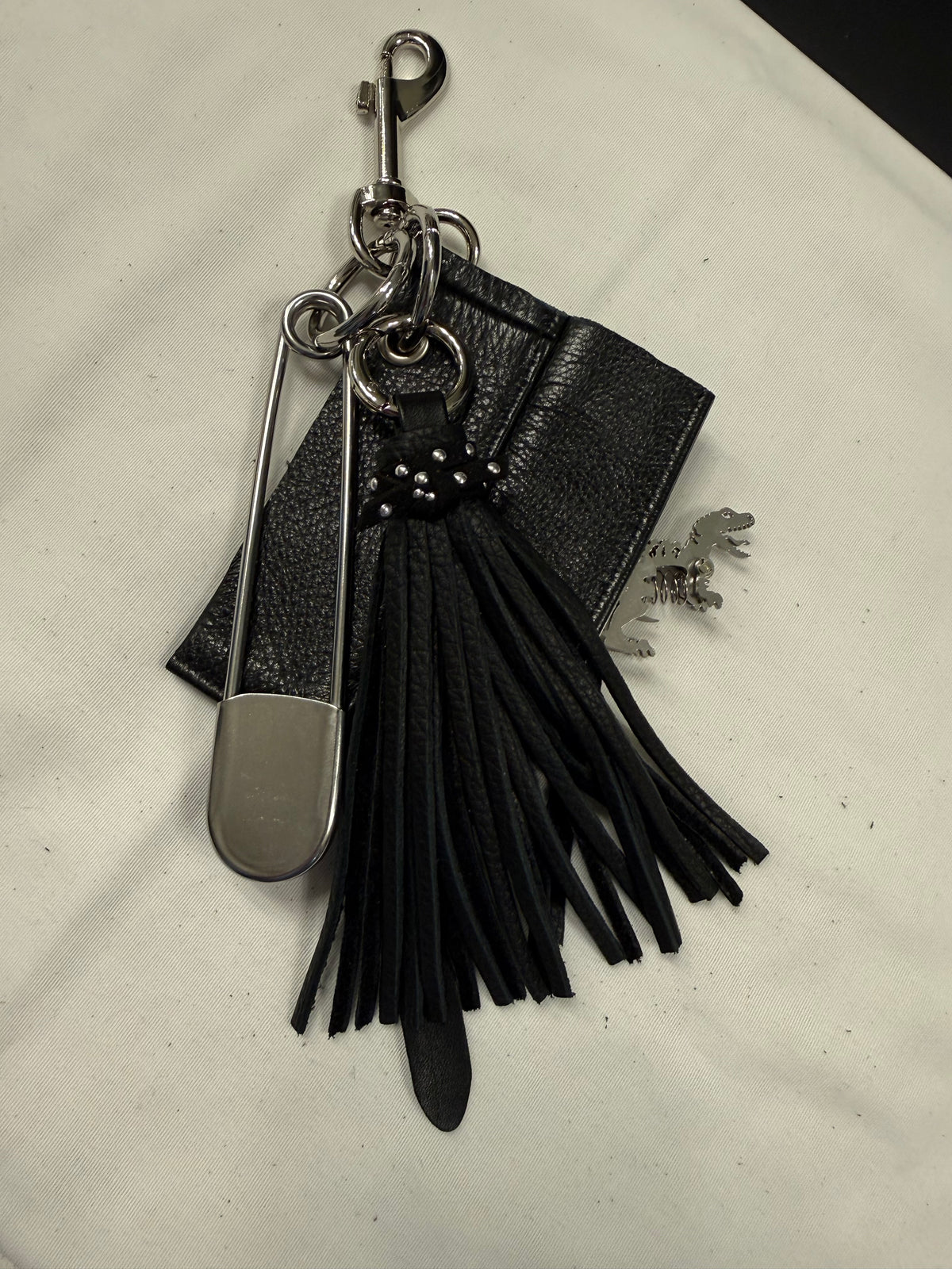Repurposed Piece of a Coach Motorcycle Jacket, XL Safety Pin, Metal T-Rex, and Leather Tassel Bag Charm Cluster