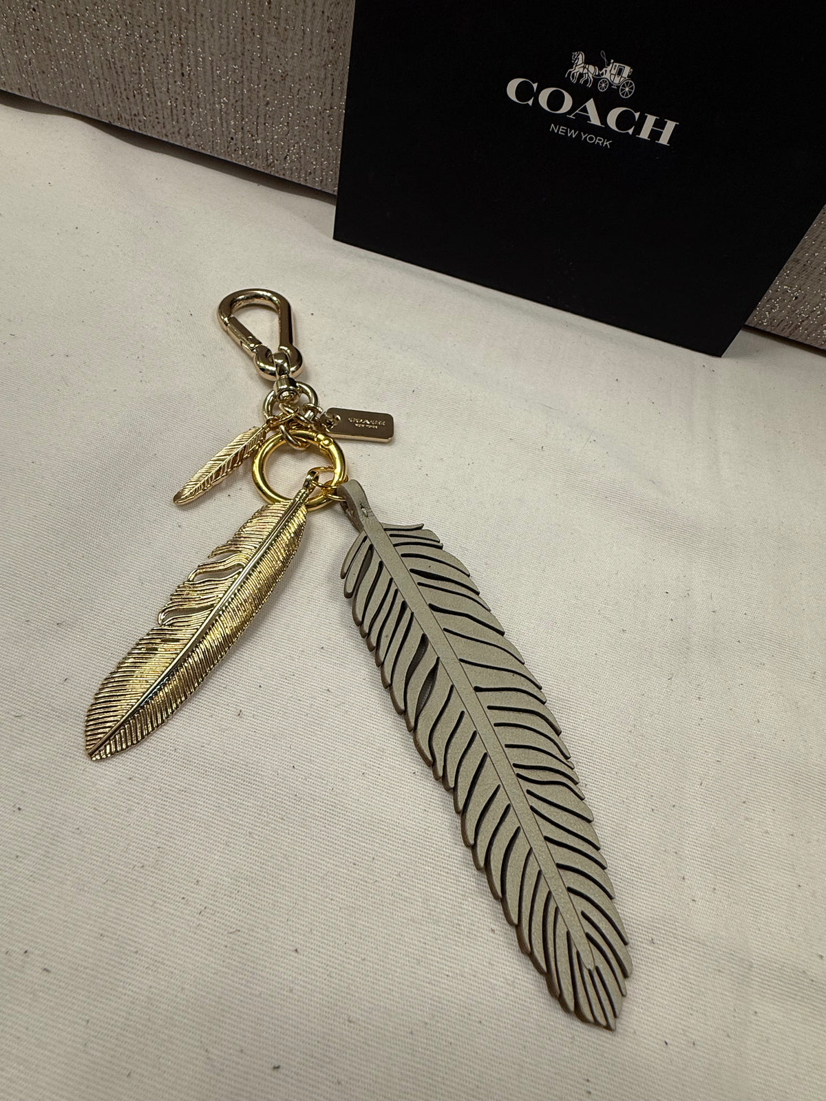 Repurposed Coach Feather and Two Gold Tone Feather Charms on a Coach Clasp