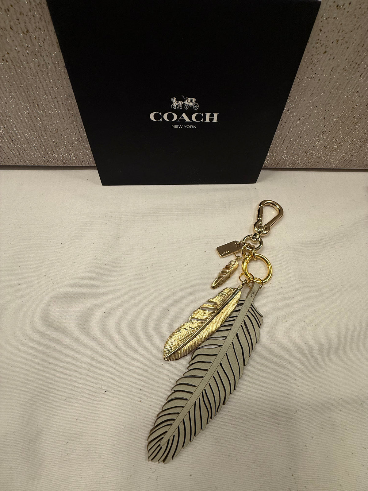 Repurposed Coach Feather and Two Gold Tone Feather Charms on a Coach Clasp