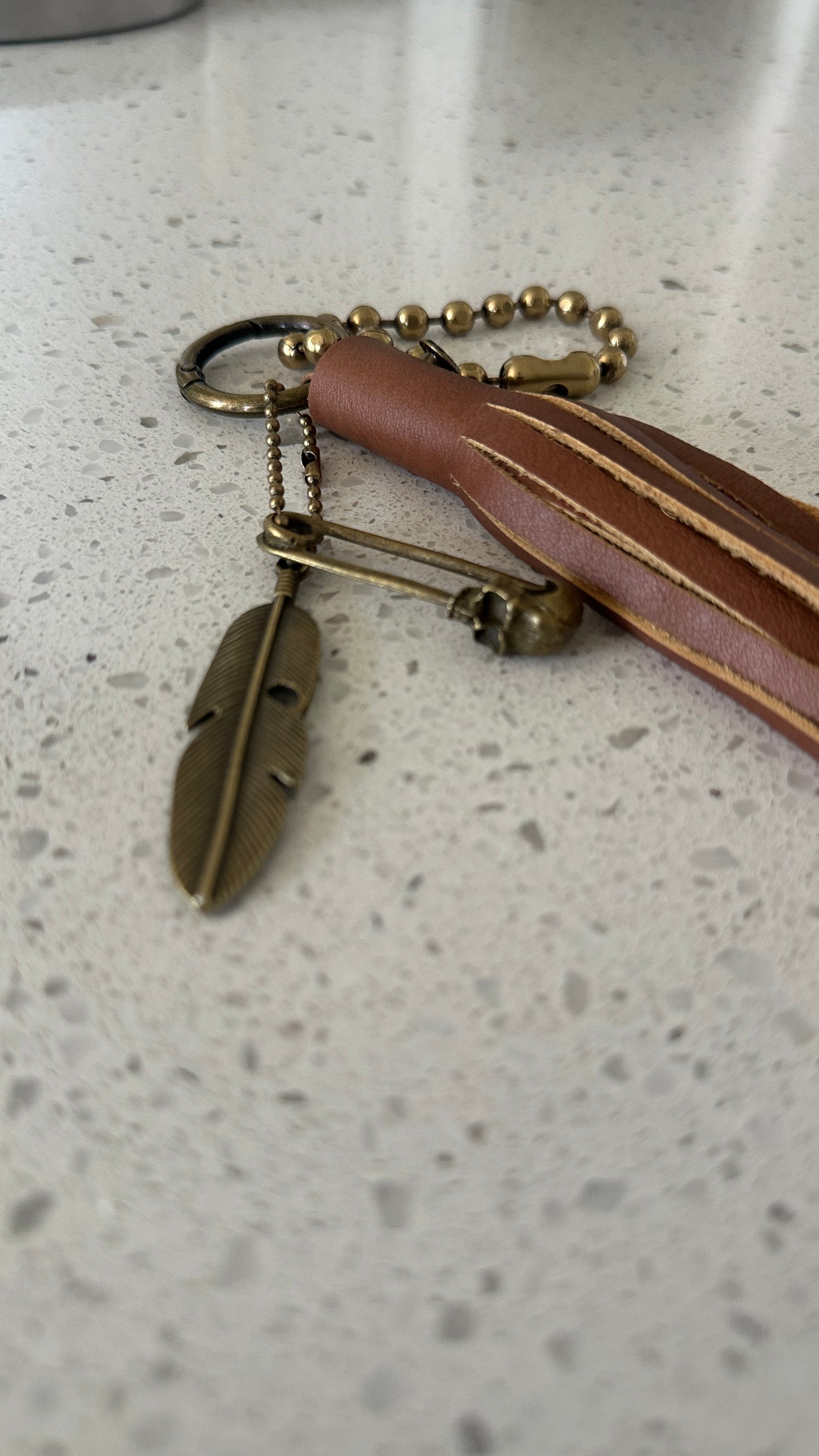 Bag Charm Cluster in Antique Brass with a Handmade Brown Leather Tassel, Coach Large Ball Chain, and Feather with Skull Safety Pin Charm