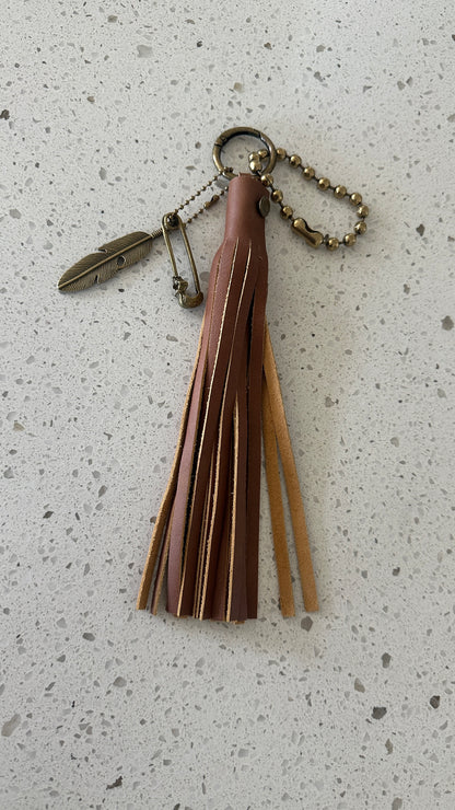 Bag Charm Cluster in Antique Brass with a Handmade Brown Leather Tassel, Coach Large Ball Chain, and Feather with Skull Safety Pin Charm