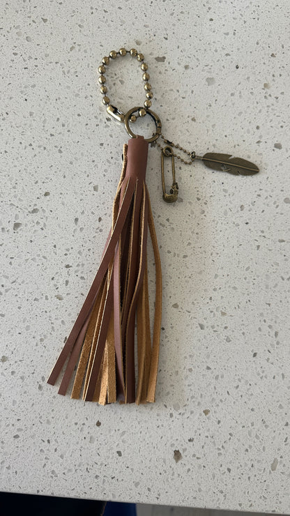 Bag Charm Cluster in Antique Brass with a Handmade Brown Leather Tassel, Coach Large Ball Chain, and Feather with Skull Safety Pin Charm