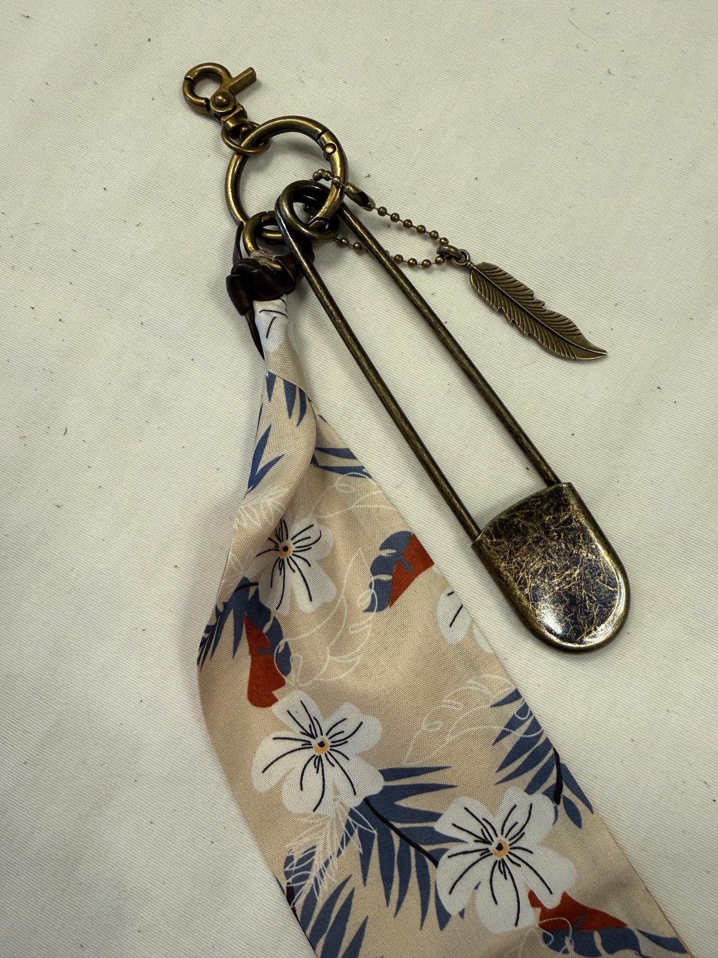 Tan & Blue Floral Scarf, Safety Pin, and Feather Bag Charm Cluster on Antique Brass Tone Hardware