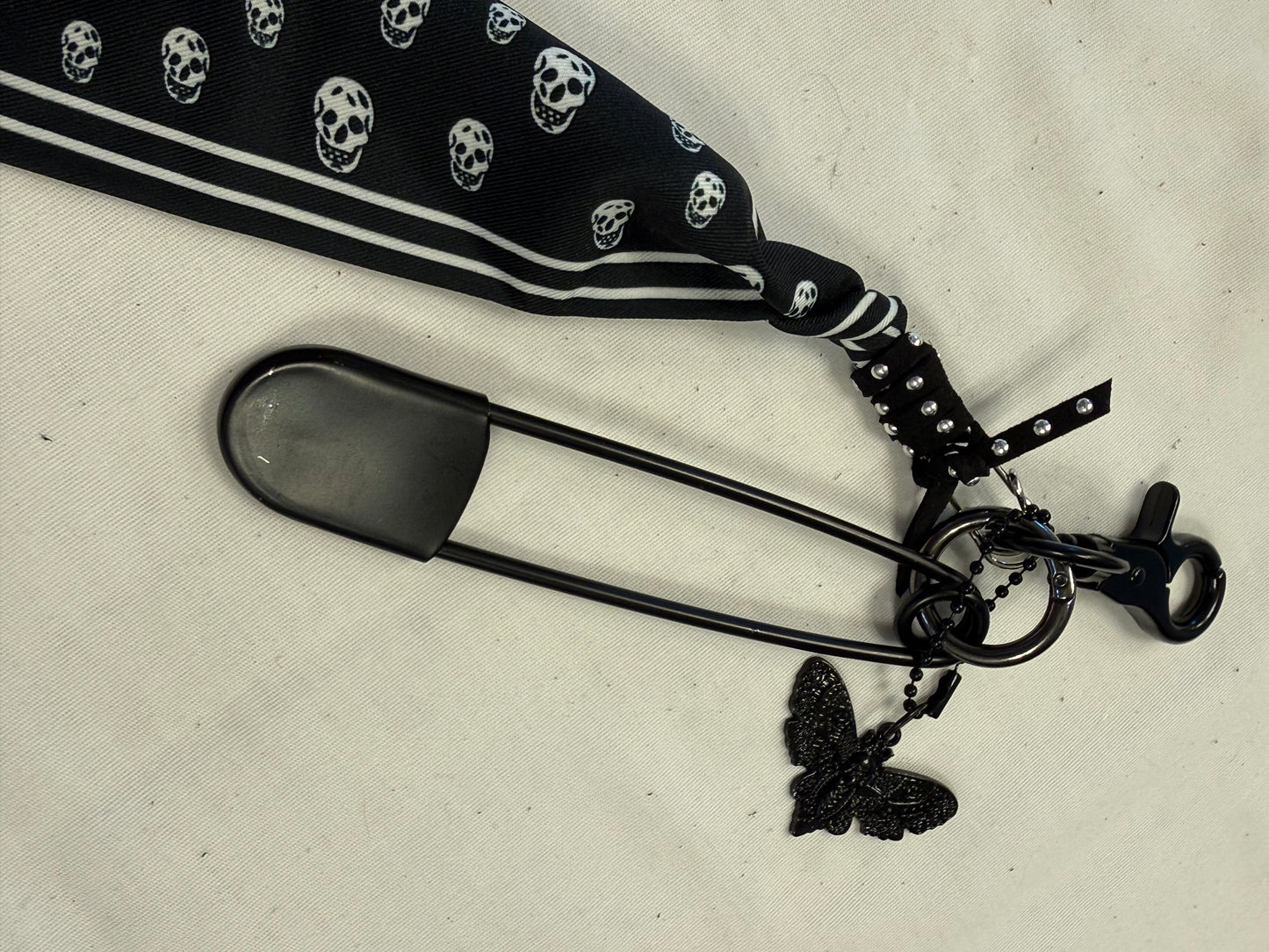 Bag Charm Cluster on Black Hardware with a Skull Scarf, XL Black Safety Pin, and Skull Moth Charm