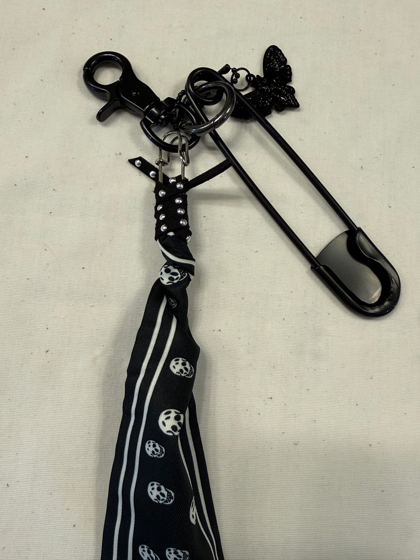 Bag Charm Cluster on Black Hardware with a Skull Scarf, XL Black Safety Pin, and Skull Moth Charm