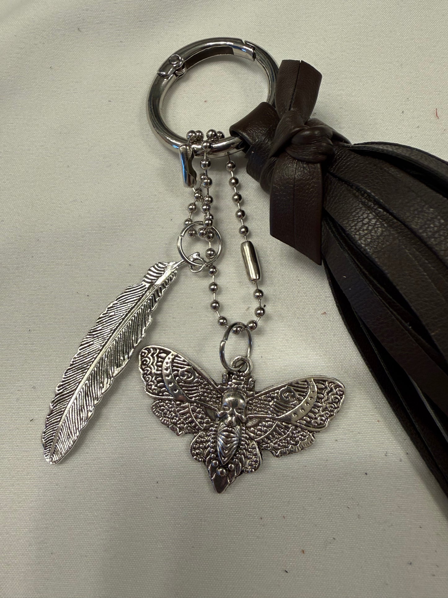Vegan Leather Handmade Tassel in Dark Maple with Silver Tone Hardware Feather and Skull Moth Bag Charm