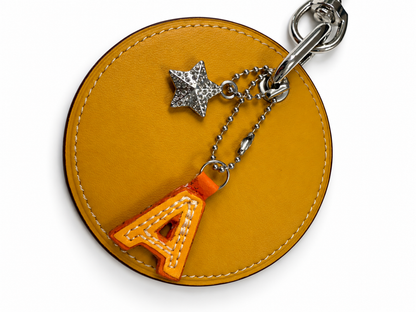 Repurposed Retro Coach Coaster with an A initial and a Coach Rhinestone Star Charm Bag Charm